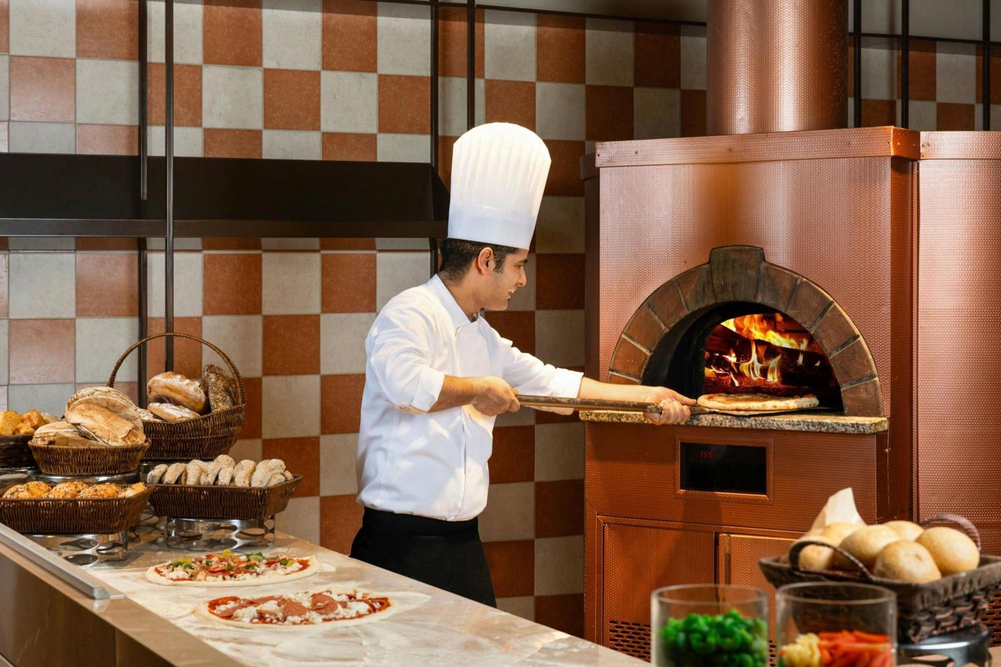 อัจมัน ซารัย อะ ลักชัวรี คอลเลคชั่น รีสอร์ต อัจมัน Hotel อัจมาน ภายนอก รูปภาพ A pizzaiolo making a pizza